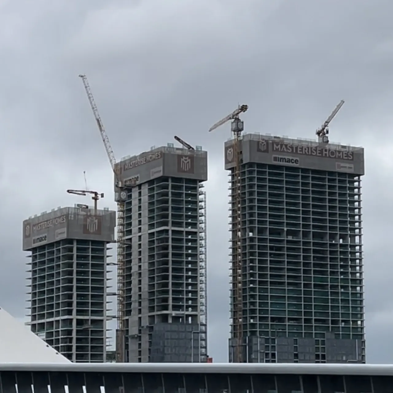 Công trường thi công tổ hợp Grand Marina Saigon với logo Masterise Homes trên đỉnh 3 tòa tháp, quận 1, TP.HCM