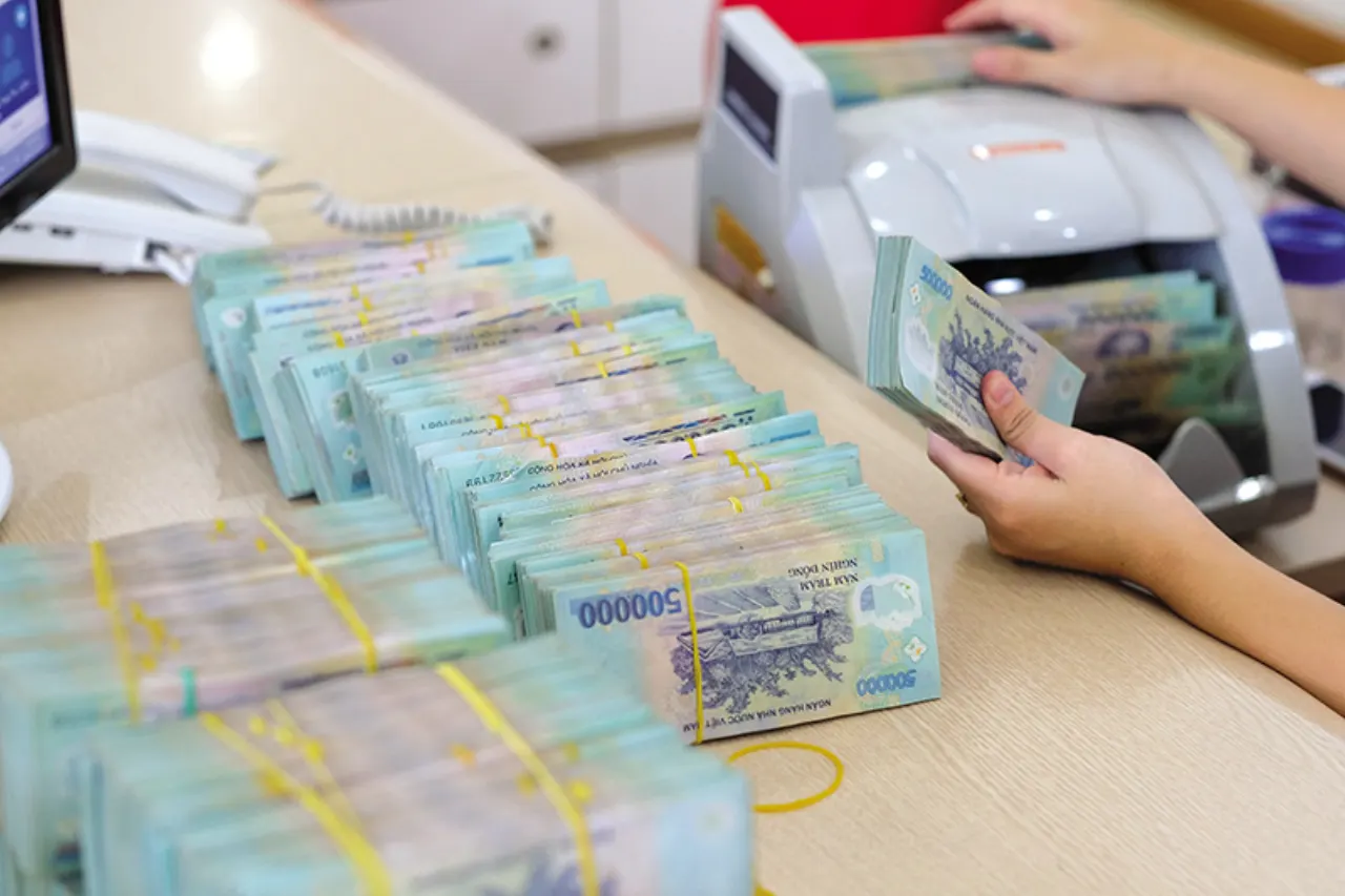 Tiền đồng Việt Nam mệnh giá lớn xếp thành cọc tại quầy giao dịch ngân hàng