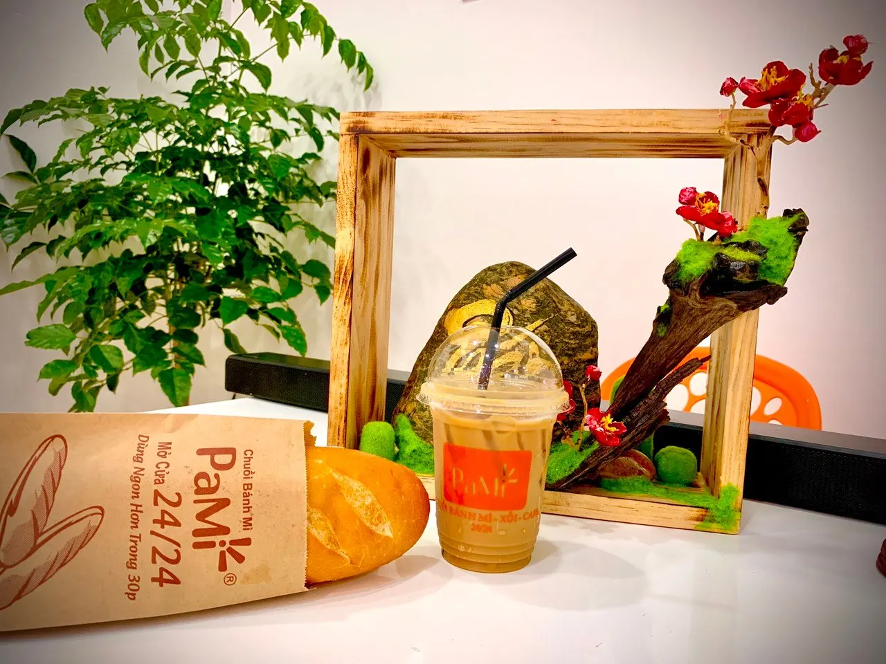 Ổ bánh mì Việt Nam gói giấy kèm ly cà phê sữa đá, món ăn sáng cầm tay phổ biến