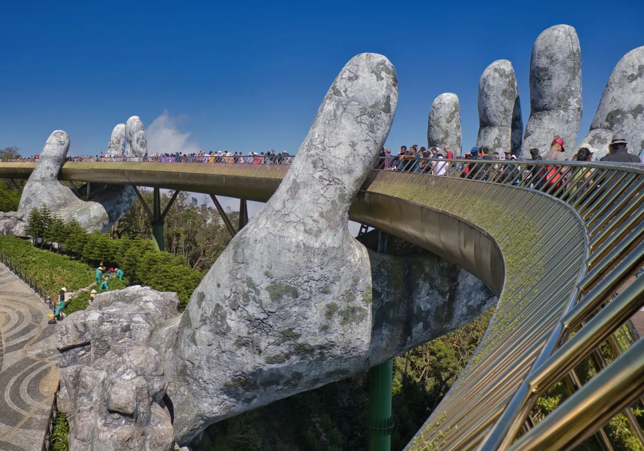 Cầu Vàng tại Bà Nà Hills dưới trời xanh nắng đẹp, hai bàn tay đá khổng lồ đỡ cầu