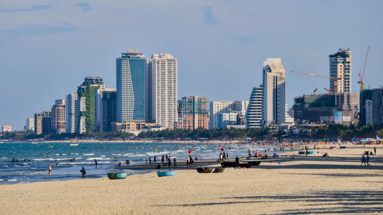 Bãi biển Mỹ Khê đông người tắm biển, nắng đẹp, skyline cao ốc Đà Nẵng phía sau